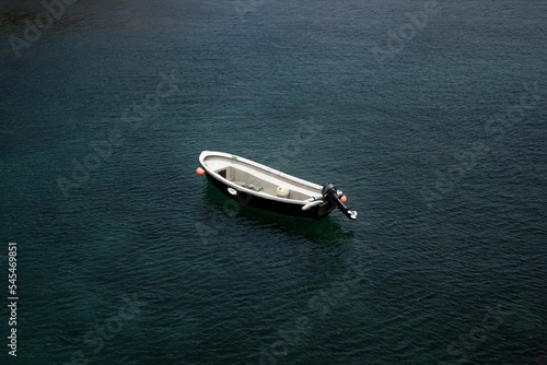 Scenic shot of an empty boat isolated in the calm sea © Ben Coull-neveu/Wirestock Creators