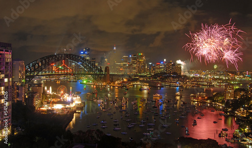 Sydney, New South Wales, Australia: Fireworks over Sydney Harbour to celebrate the New Year. Firework display with bridge, city and harbor.