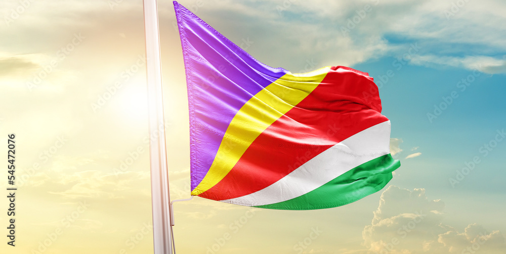 Waving Flag of Seychelles in Blue Sky. The symbol of the state on wavy cotton fabric.