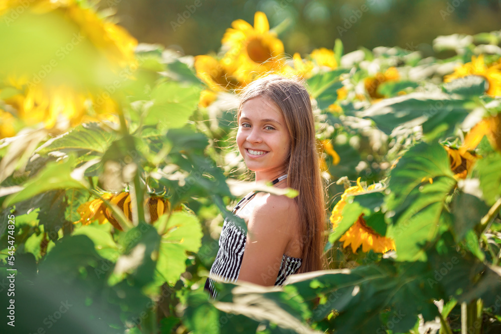 Cute Caucasian teen girl smiling in a field of sunflowers. Summer time concept. Cute Caucasian teen girl smiling in a field of sunflowers. Summer time concept.