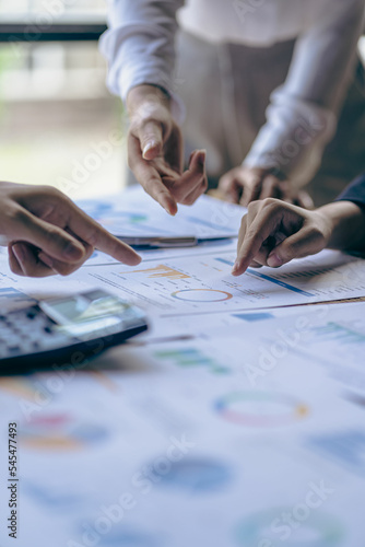 Young colleagues working together on startup projects in modern office Businessman brainstorming analyzing financial graphs calculating company earnings Vertical photo, flare