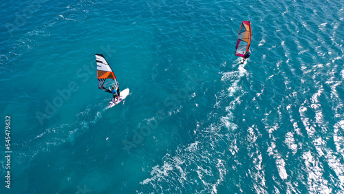 Photography Aerial frone view photo of fit man practising wind surfing in Mediterranean bay
