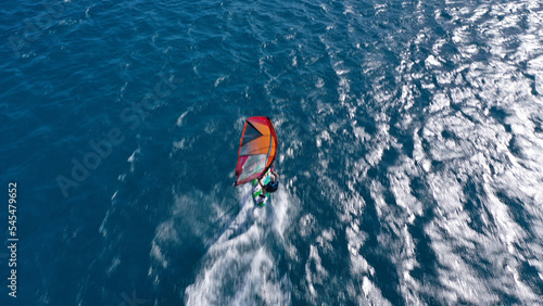 Aerial frone view photo of fit man practising wind surfing in Mediterranean bay with crystal clear deep blue sea