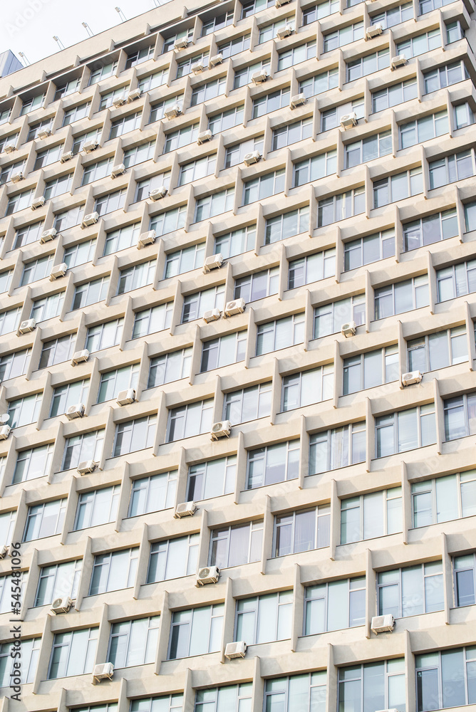 a building with lots of windows and air conditioners a building with lots of windows and air conditioners