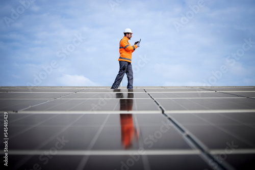 Renewable energy sources and solar engineer checking photovoltaic panels and electricity production.