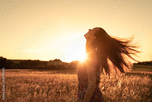Foto Gorgeous young woman in a wheat field on a sunset background