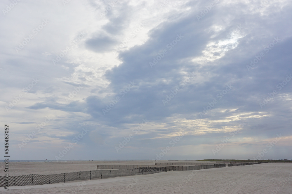 Jones Beach State Park, New York, USA: Fencing protects this Long Island beach from wind erosion as clouds gather over head at sunset.