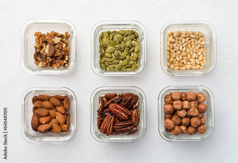 Bowl with different nuts walnut, pumpkin, pine nut, almond, pecan, hazelnut, top view on white background Bowl with different nuts walnut, pumpkin, pine nut, almond, pecan, hazelnut, top view on white background