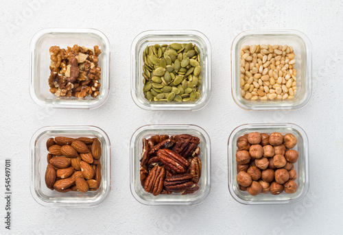 Bowl with different nuts walnut, pumpkin, pine nut, almond, pecan, hazelnut, top view on white background