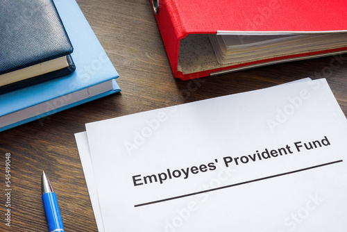 Documents about Employees Provident Fund and red folder. photo