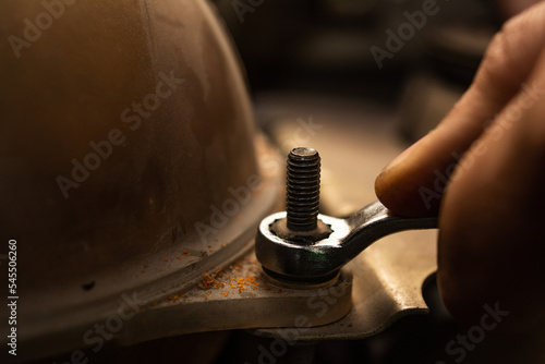 The hands of a mechanic tightening a nut (ID: 545506260)