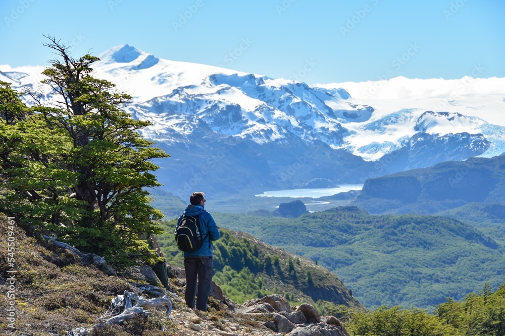 hiker enjoying view of andes mountains glaciers and lakes at Torres del Paine national park, Chile