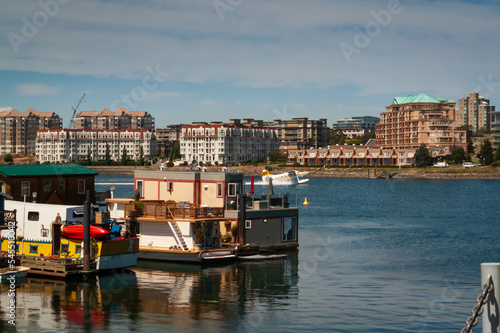 Boat houses at Fisherman wharf with apartments buildings in background in Victoria, British Columbia, Canada