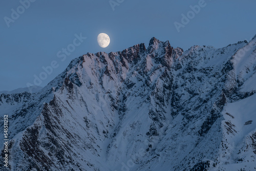 The moon rises above Piz Fess (2880m) in the Lepontine Alps, Grisons, Switzerland