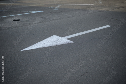 white arrow straight ahead direction of movement, direction of movement to the right, direction arrow for parking, white arrow on gray asphalt, asphalt texture, pedestrian crossing symmetrical