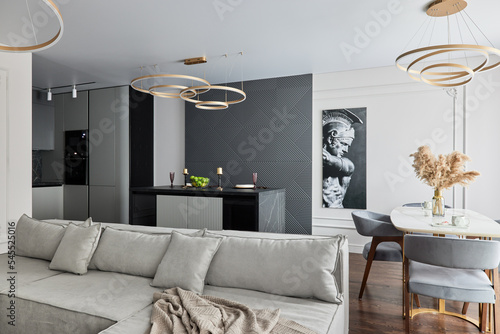 Modern interior of studio apartment in gray and  white colors and tones. White furniture and door. Expensive and luxury design