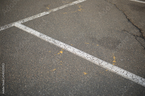 white lines abstract on asphalt, road markings white stripes on the asphalt road, parking spaces separated by white lines, symmetrical abstract lines on gray asphalt