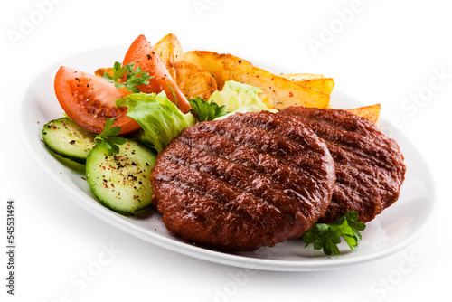 Grilled beefsteaks, baked potatoes and vegetable salad