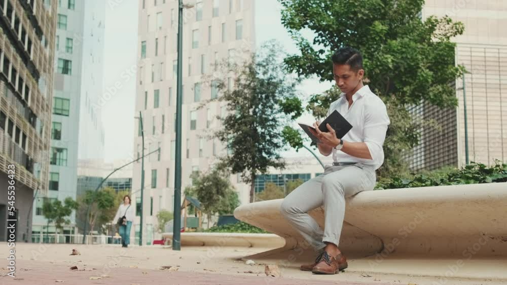 Young businessman making notes in personal paper planner Young businessman making notes in personal paper planner