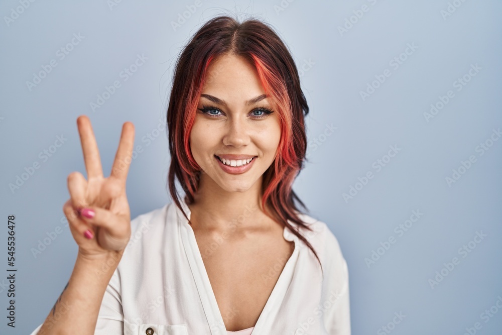 Young caucasian woman wearing casual white shirt over isolated background showing and pointing up with fingers number two while smiling confident and happy. Young caucasian woman wearing casual white shirt over isolated background showing and pointing up with fingers number two while smiling confident and happy.