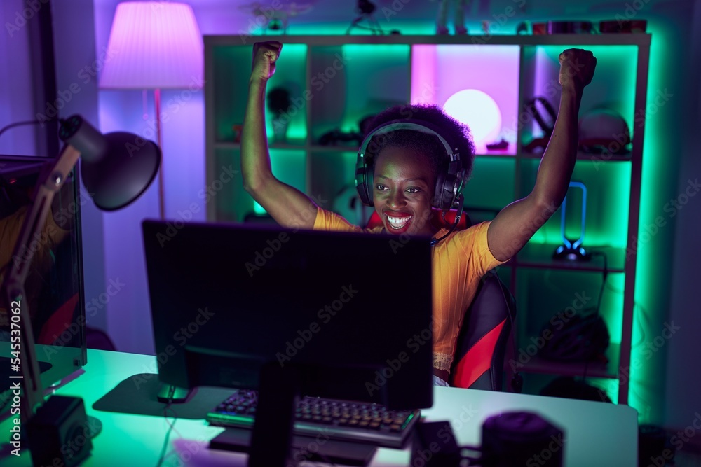 African american woman streamer using computer with winner expression ...