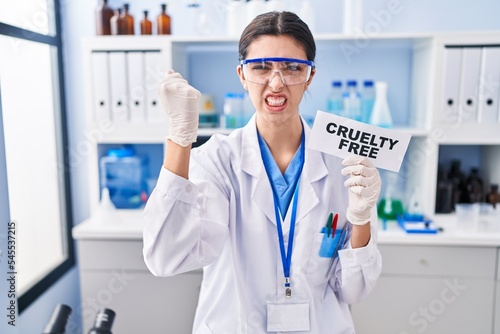 Young beautiful woman working on cruelty free laboratory annoyed and frustrated shouting with anger, yelling crazy with anger and hand raised