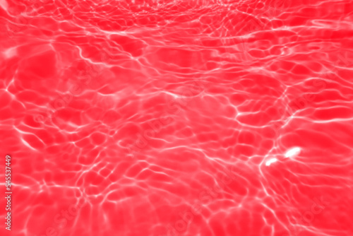 Defocus blurred transparent red colored clear calm water surface texture with splashes and bubbles. Trendy abstract nature background. Water waves in sunlight with copy space. Red watercolor shining