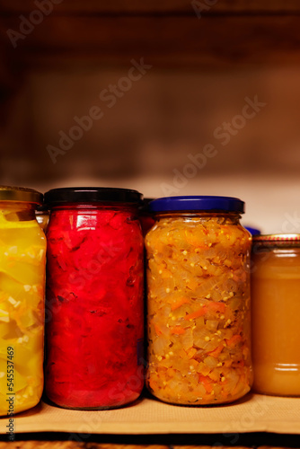Various fruits and vegetables canned at home. Preserved vegetables in the pantry. Fall home food preserving or canning. Copy space