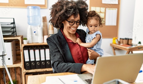 Young african american woman smiling confident working with baby at office photo