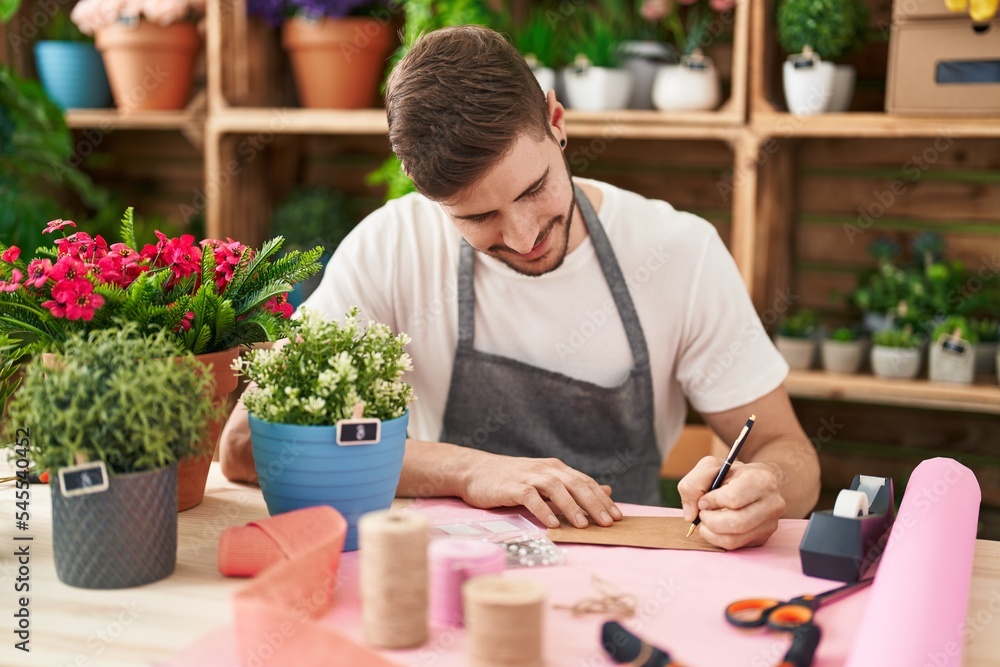 Young caucasian man florist smiling confident writing on envelope letter at flower shop Young caucasian man florist smiling confident writing on envelope letter at flower shop
