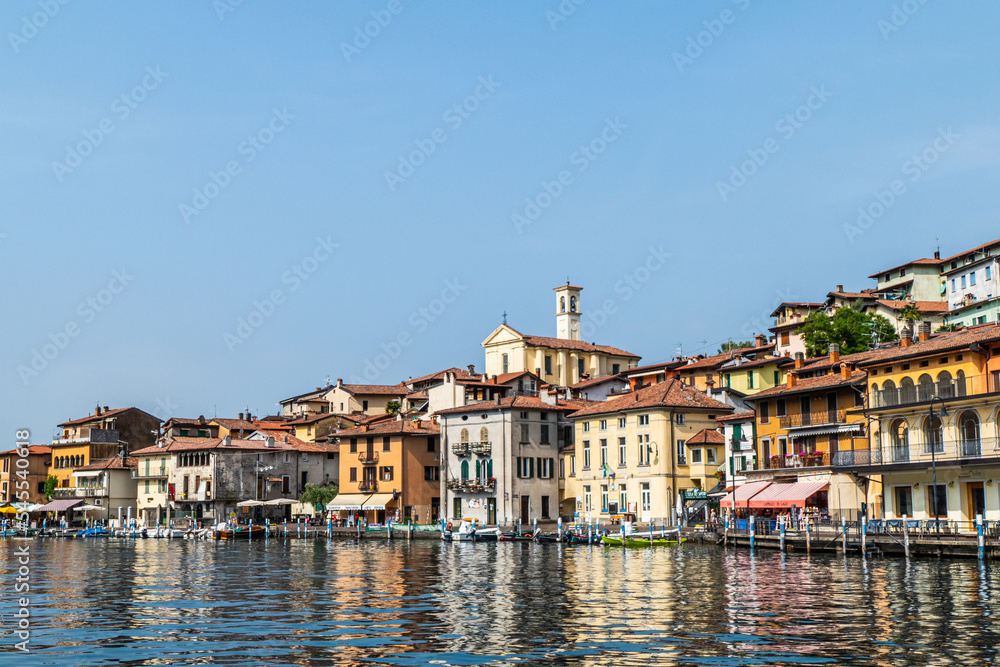 Landscape of the lakeside of Peshiera Maraglio in Monte Isola with beautiful colored houses reflecting in the water