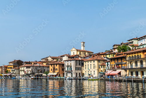 Landscape of the lakeside of Peshiera Maraglio in Monte Isola with beautiful colored houses reflecting in the water photo