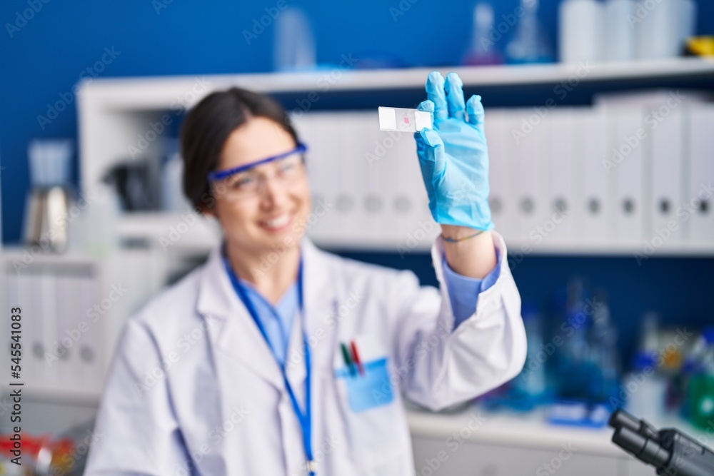 Young woman scientist holding sample at laboratory