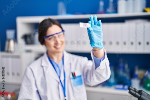 Young woman scientist holding sample at laboratory