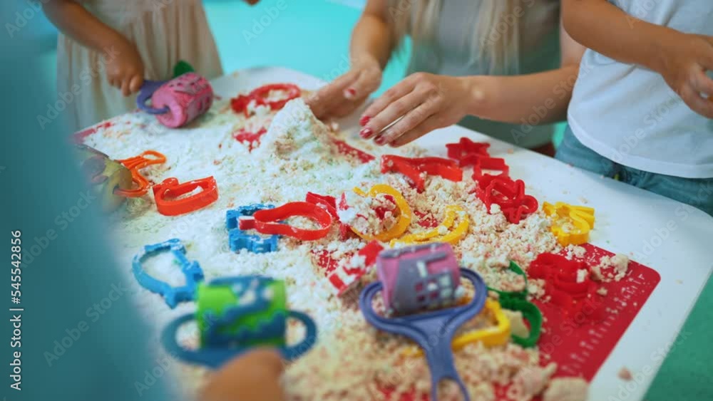 closeup view of the kids and their teacher playing together with kinetic sand at the nursery. High quality 4k footage closeup view of the kids and their teacher playing together with kinetic sand at the nursery. High quality 4k footage