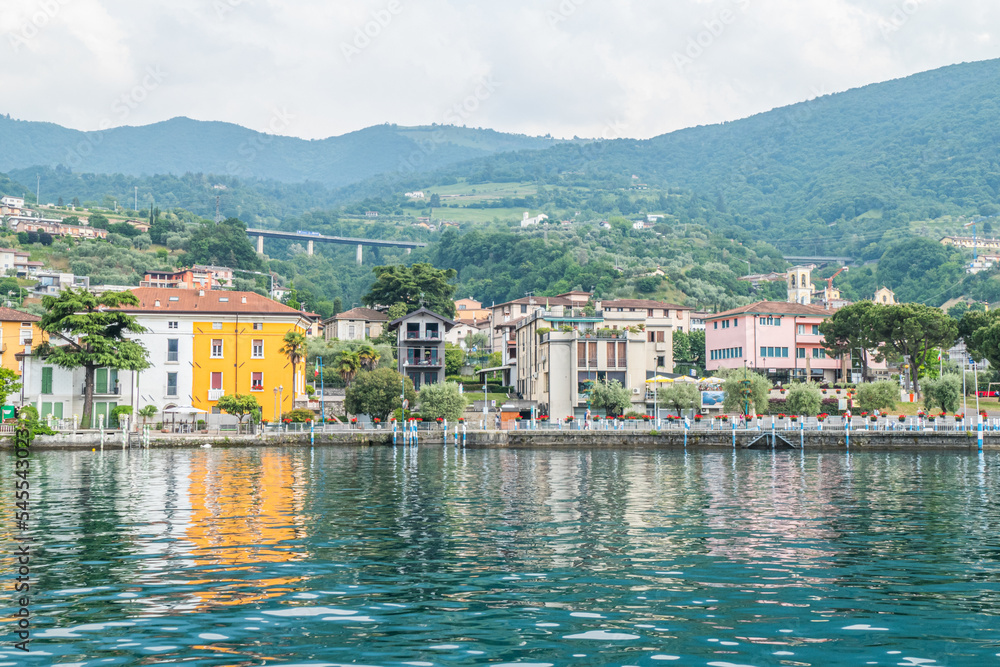 Panorama of the lakeside of Sulzano with colored houses that reflecting in the Lake Iseo