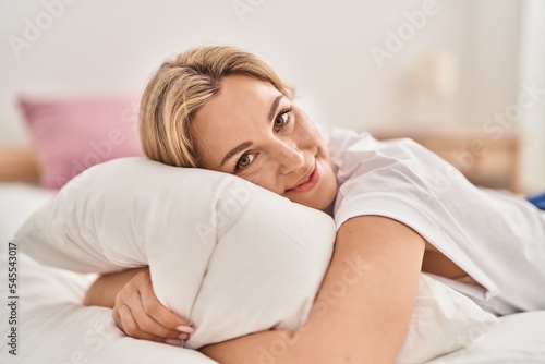 Young blonde woman relaxed lying on bed at bedroom