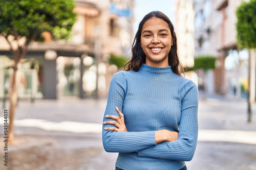 Young african american woman smiling confident standing with arms crossed gesture at street