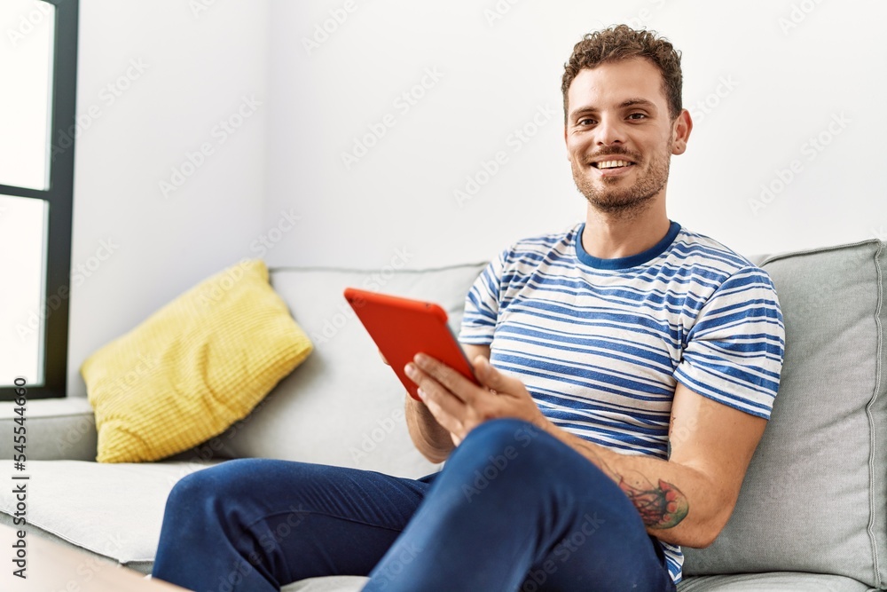 Young hispanic man smiling confident using touchpad at home Young hispanic man smiling confident using touchpad at home