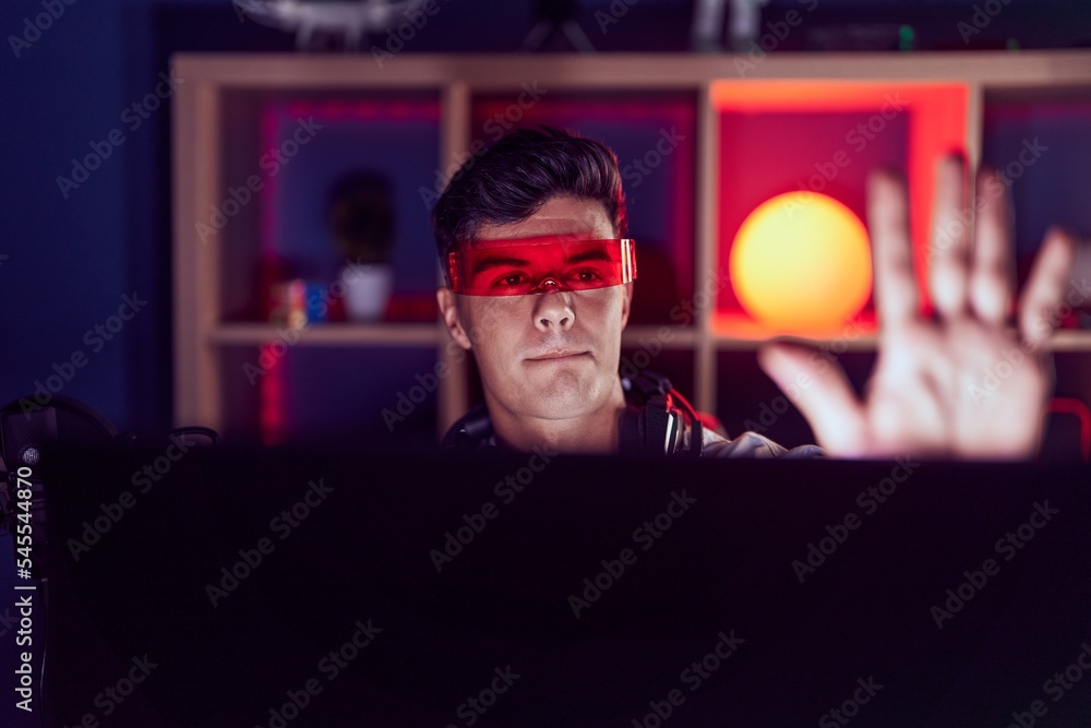 Young hispanic man streamer playing video game using virtual reality glasses at gaming room Young hispanic man streamer playing video game using virtual reality glasses at gaming room
