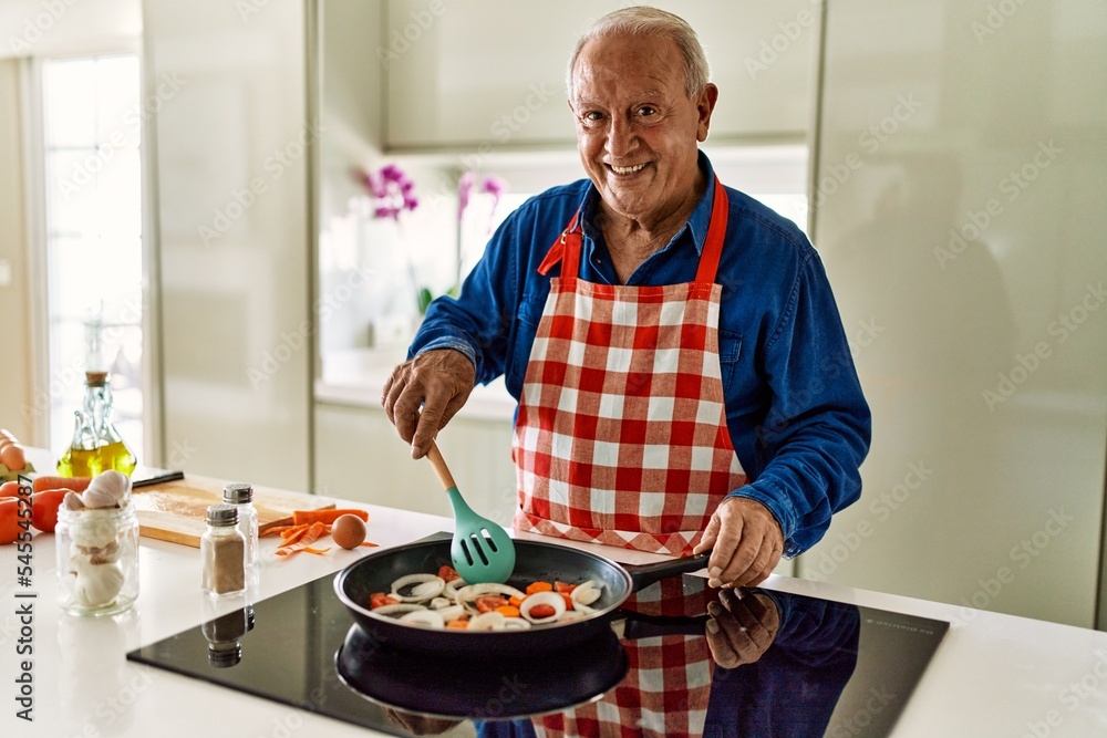 Senior man smiling confident cooking at kitchen Senior man smiling confident cooking at kitchen