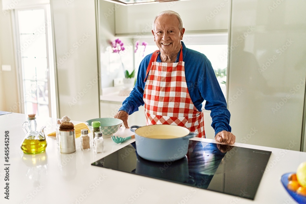 Senior man smiling confident cooking spaghetti at kitchen Senior man smiling confident cooking spaghetti at kitchen