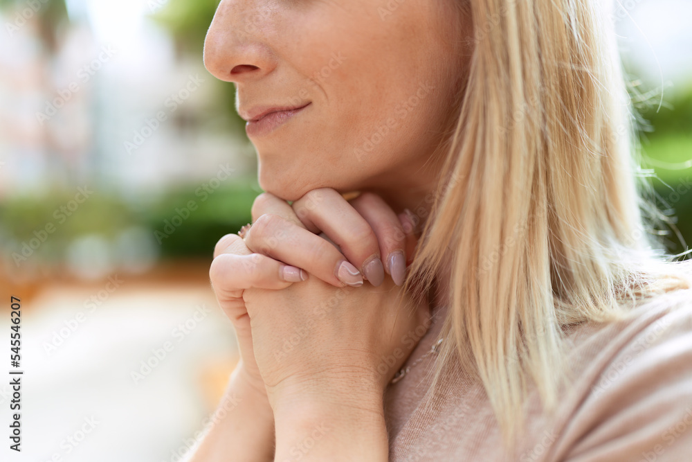 Young blonde woman praying with closed eyes at park Young blonde woman praying with closed eyes at park