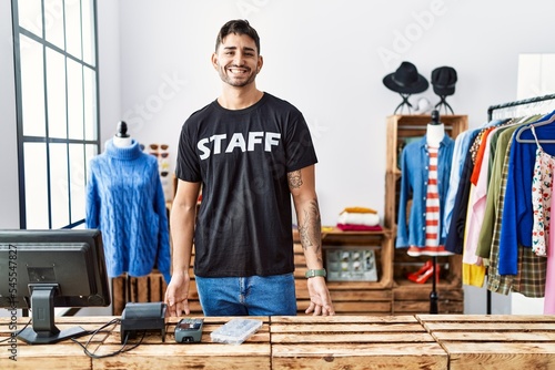 Young hispanic man working at retail boutique with a happy and cool smile on face. lucky person.