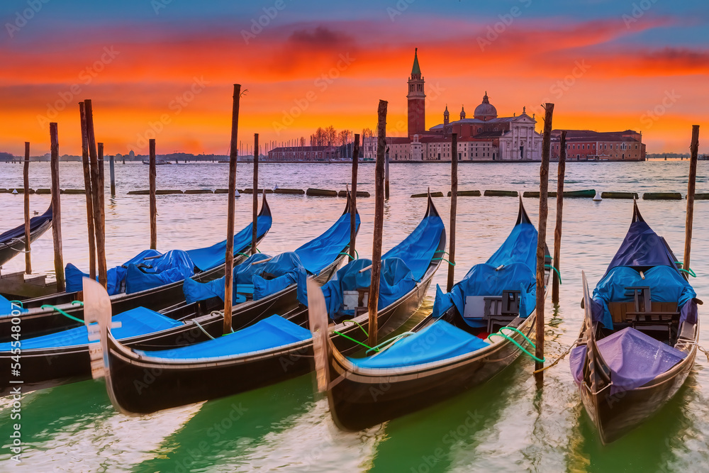 Gondolas in Venice at red sunrise