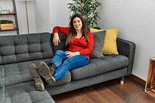 Young woman smiling confident sitting on sofa at home
