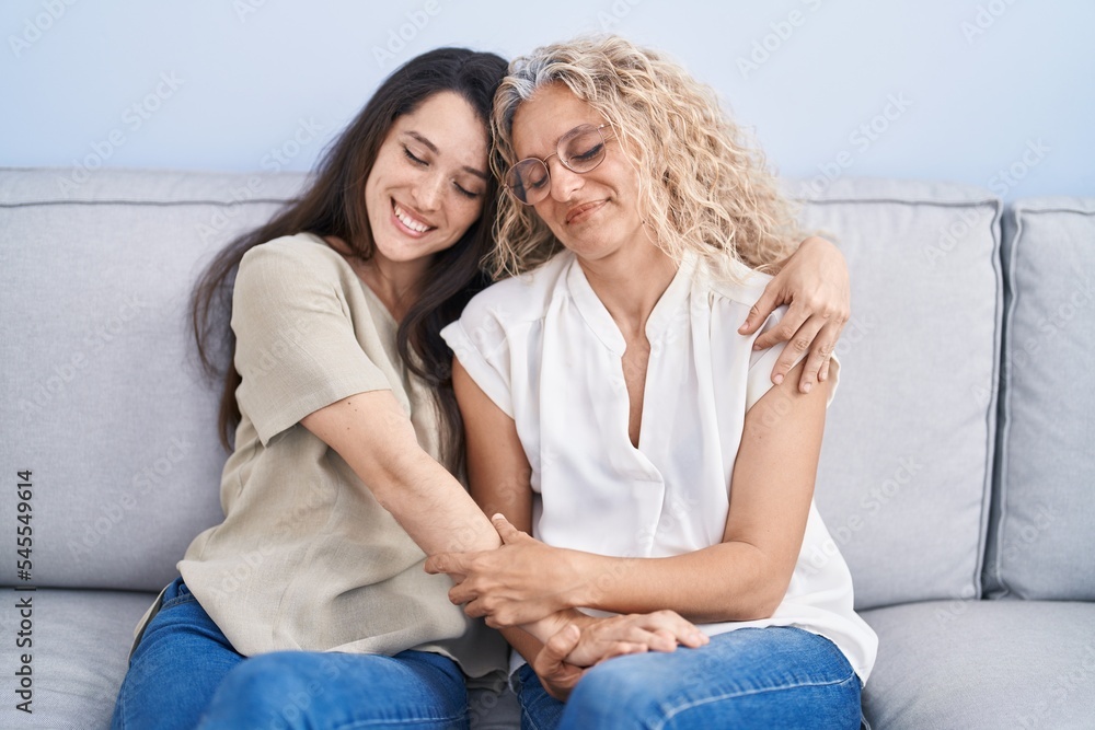 Two women mother and daughter hugging each other at home Two women mother and daughter hugging each other at home