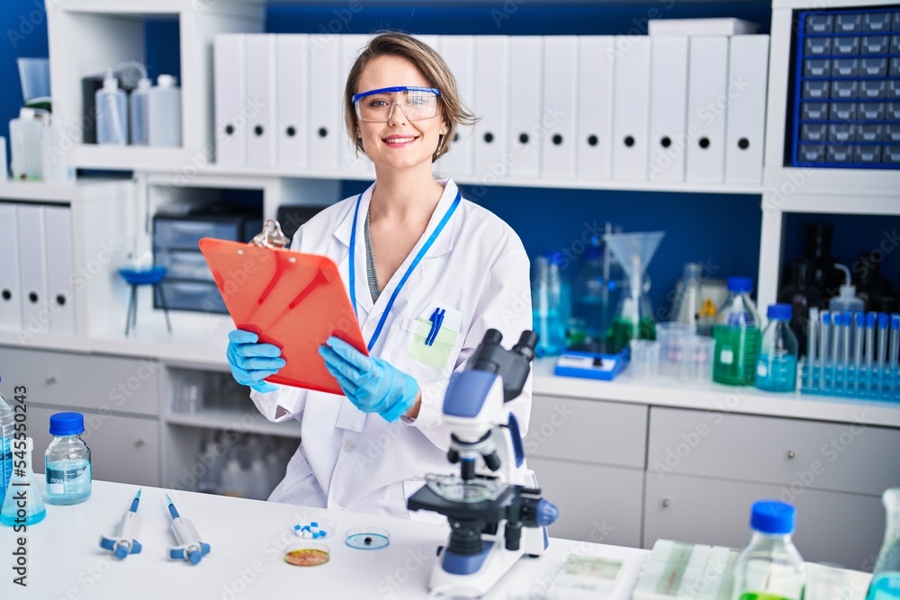 Young woman scientist reading report at laboratory