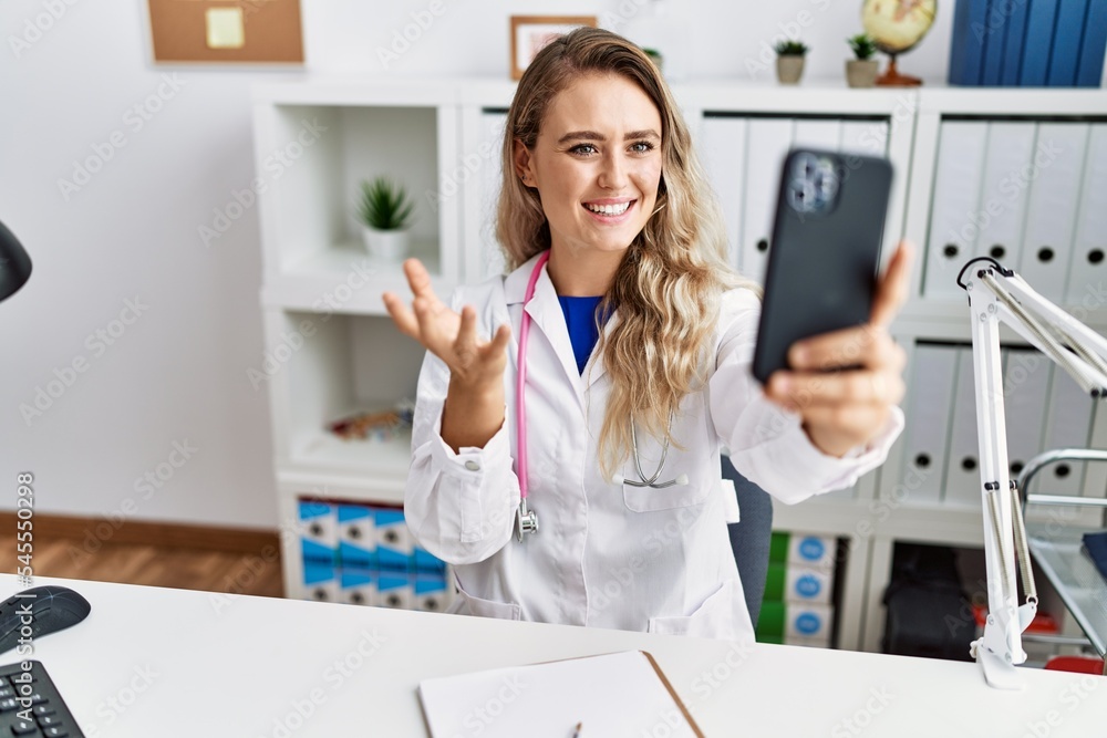 Young woman wearing doctor uniform having telemedicine at clinic Young woman wearing doctor uniform having telemedicine at clinic