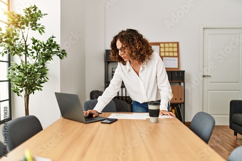 Mature hispanic woman working at the office